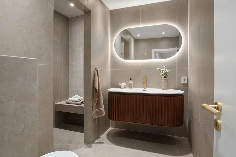 Completed Marienlyst bathroom with timber-front vanity, illuminated mirror and light finishes